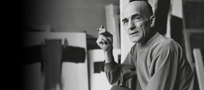 Portrait of Paul-Émile Borduas, sitting in his studio and smoking a cigarette.