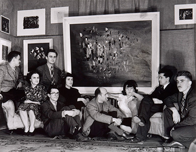 Photo of the Second Automatist exhibit in which we see artists sitting in front of a Borduas painting.