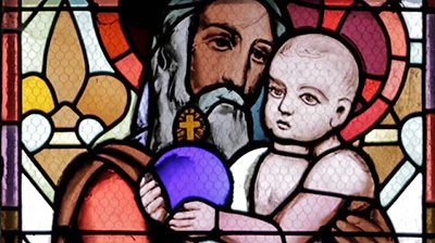 Scene from the video showing the detail of a stained-glass window representation of St-Joseph holding Baby Jesus.