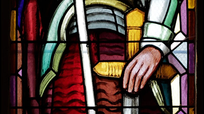 Scene from the video showing the detail of a stained-glass window representation of Jeanne d'Arc's sword.